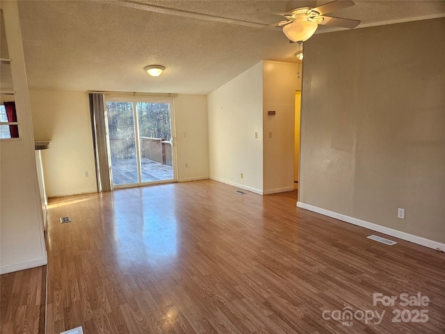 interior space featuring ceiling fan, wood-type flooring, and a textured ceiling