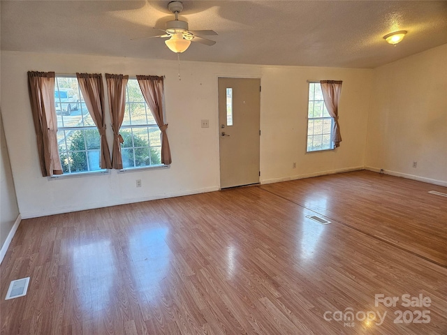 interior space featuring hardwood / wood-style flooring, plenty of natural light, ceiling fan, and a textured ceiling