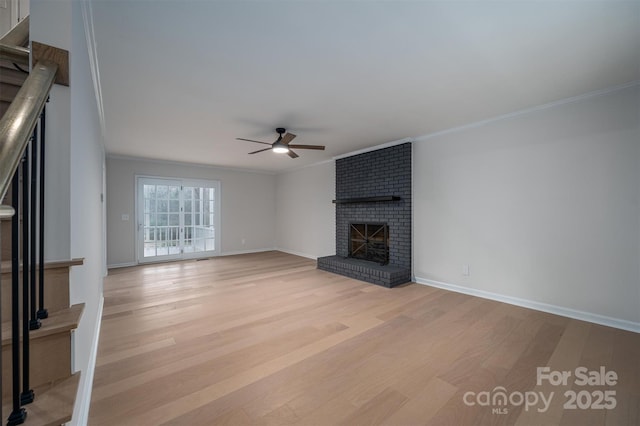 unfurnished living room featuring ceiling fan, ornamental molding, a fireplace, and light hardwood / wood-style flooring