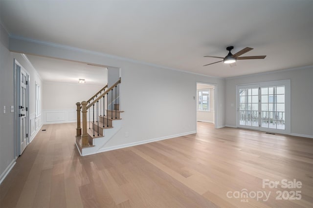 unfurnished living room with ceiling fan, light wood-type flooring, and ornamental molding