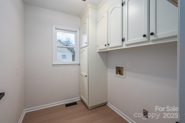 clothes washing area featuring cabinets, light wood-type flooring, and hookup for a washing machine