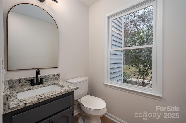 bathroom featuring vanity, toilet, and a wealth of natural light