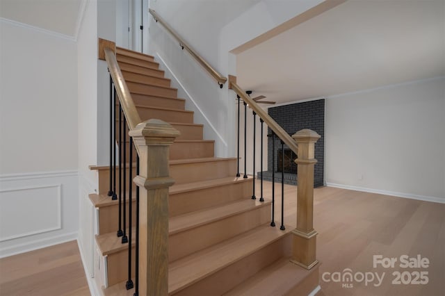 stairs featuring hardwood / wood-style flooring and ornamental molding