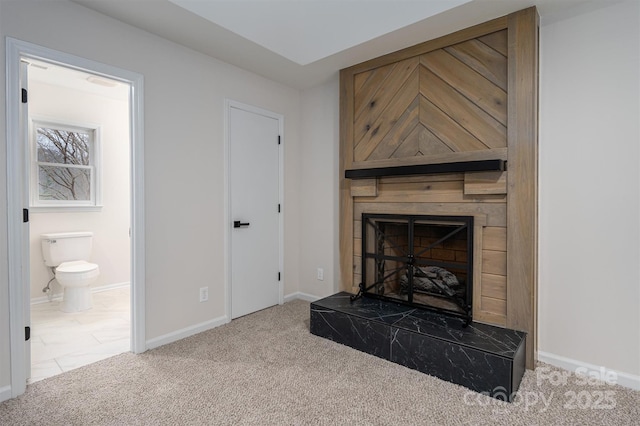 carpeted living room with a high end fireplace