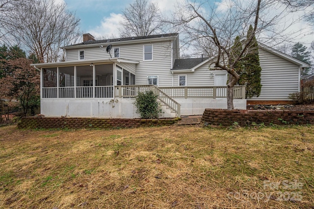 back of house with a deck, a lawn, and a sunroom