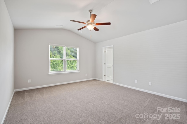 carpeted spare room with ceiling fan and lofted ceiling