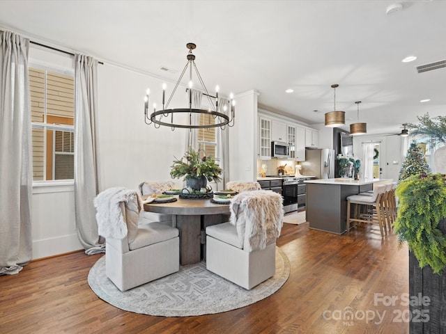 dining area with dark hardwood / wood-style flooring and an inviting chandelier