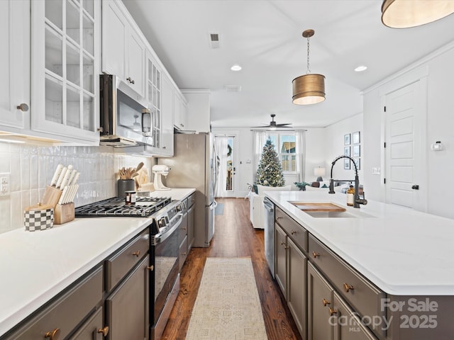 kitchen featuring white cabinets, sink, hanging light fixtures, ceiling fan, and stainless steel appliances