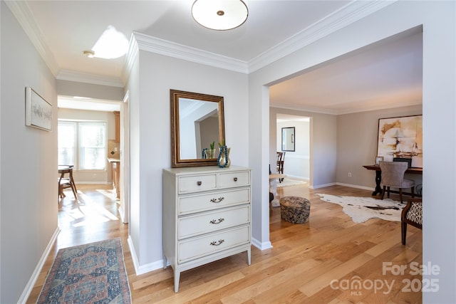 corridor with light wood-type flooring and crown molding