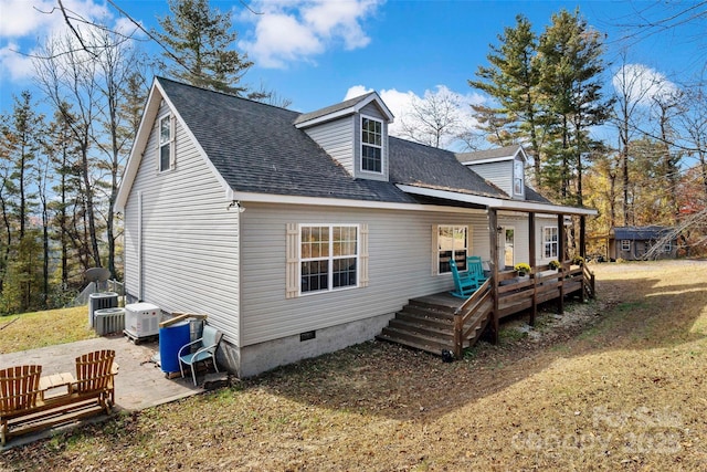 rear view of house with a lawn, a deck, central AC unit, a storage shed, and a patio