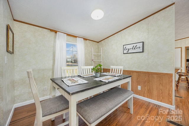 dining area with hardwood / wood-style flooring and ornamental molding