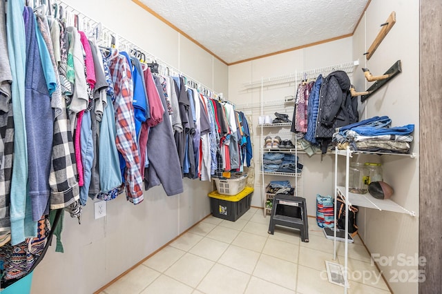 walk in closet with light tile patterned floors