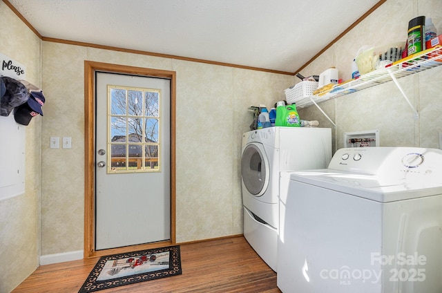 clothes washing area with hardwood / wood-style flooring, separate washer and dryer, and ornamental molding