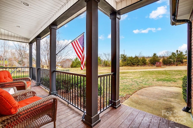 wooden deck with a lawn and covered porch