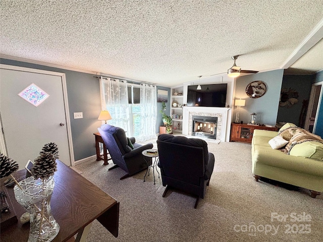 carpeted living room with built in shelves, a textured ceiling, a stone fireplace, and ceiling fan