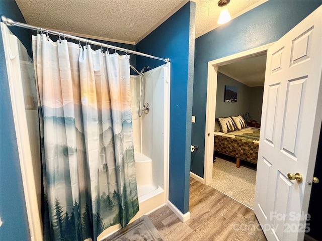 bathroom featuring curtained shower, wood-type flooring, a textured ceiling, and ornamental molding