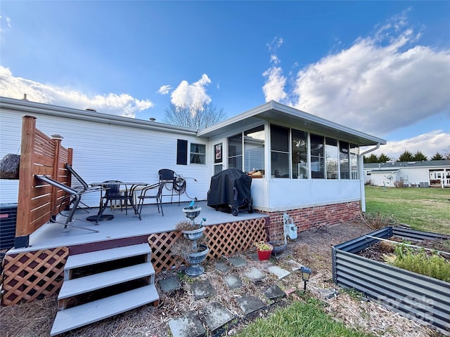 back of property featuring a sunroom and a deck