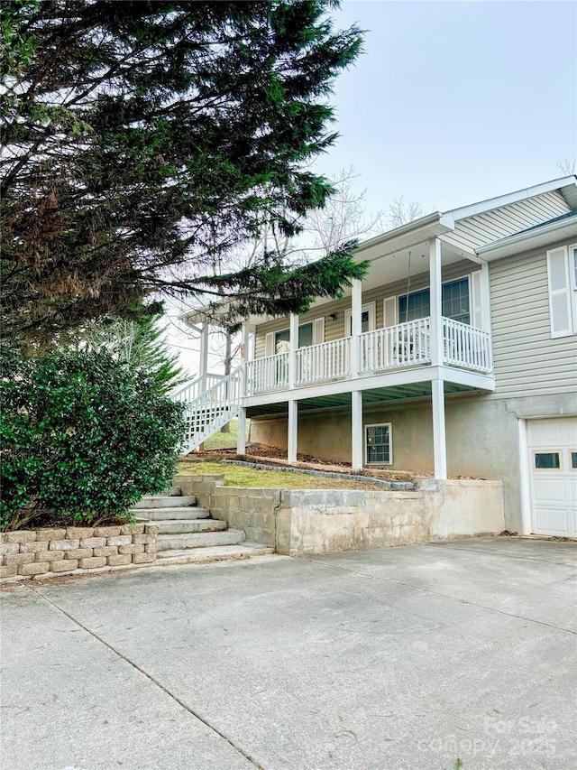 view of side of property featuring a balcony and a garage