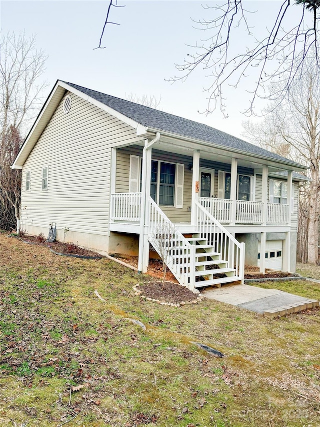 ranch-style home featuring a garage, a front lawn, and a porch