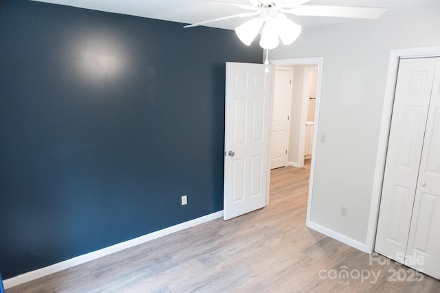 unfurnished bedroom featuring ceiling fan, a closet, and light hardwood / wood-style flooring