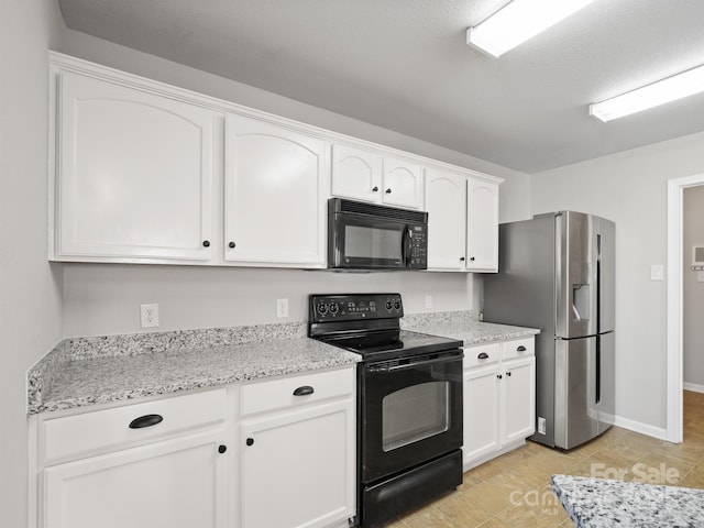 kitchen with black appliances, light stone countertops, and white cabinets