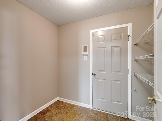 interior space featuring baseboards and a textured ceiling