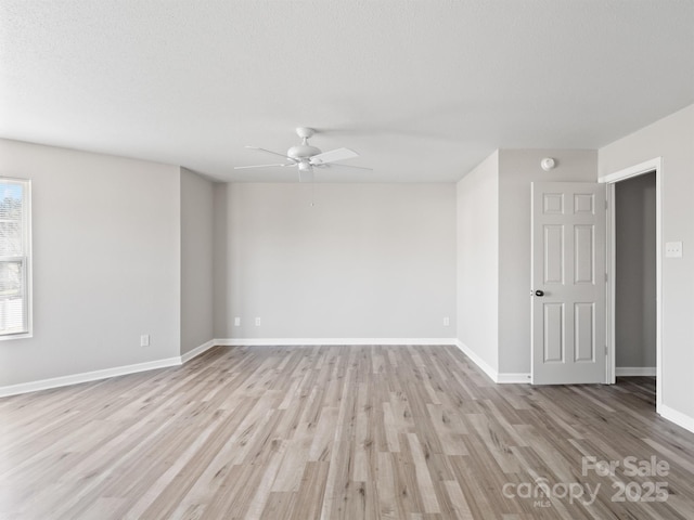 spare room with light wood finished floors, baseboards, and a ceiling fan