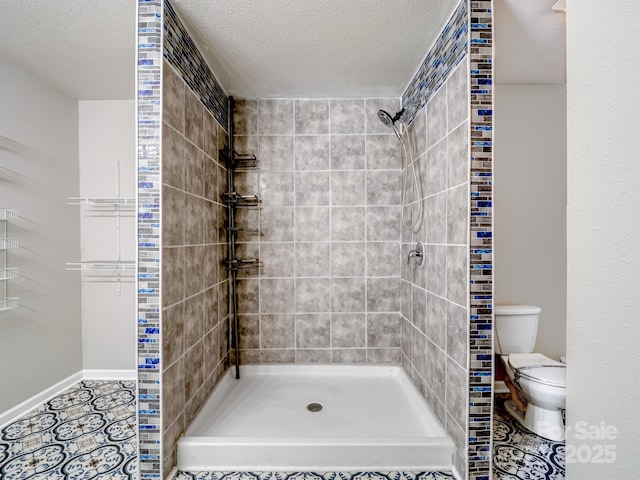 bathroom featuring a shower stall, toilet, and a textured ceiling