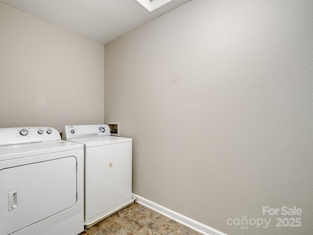 laundry room featuring washing machine and dryer, laundry area, a textured ceiling, and baseboards