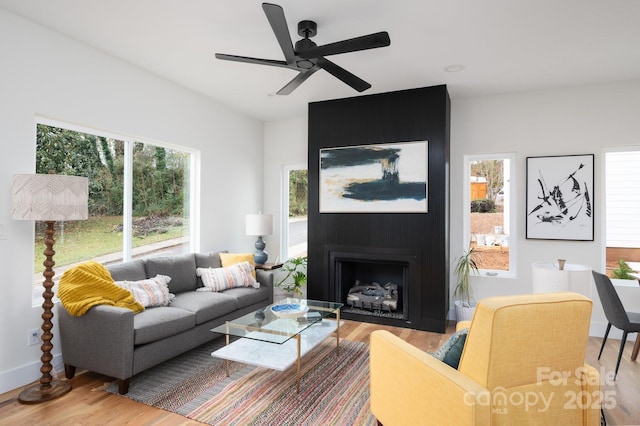 living room with hardwood / wood-style floors, plenty of natural light, ceiling fan, and a fireplace