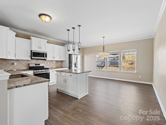 kitchen featuring dark stone countertops, sink, stainless steel appliances, and a center island