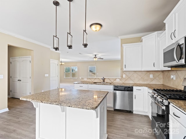 kitchen featuring a kitchen island, appliances with stainless steel finishes, a breakfast bar, decorative light fixtures, and ceiling fan