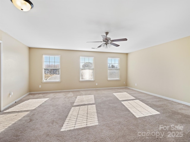 spare room featuring ceiling fan, light colored carpet, and plenty of natural light