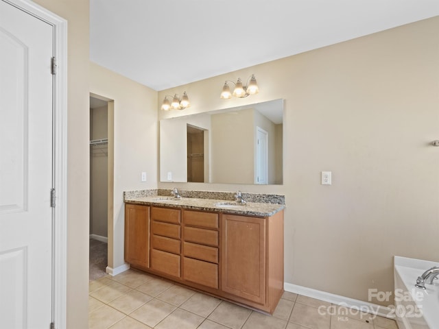 bathroom featuring tile patterned flooring, vanity, and a tub