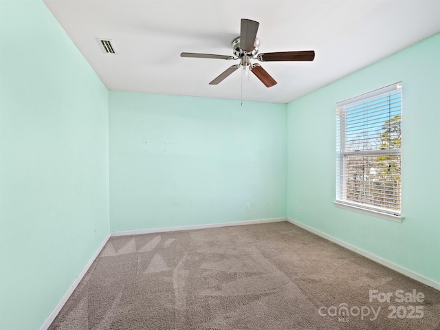 carpeted spare room with ceiling fan