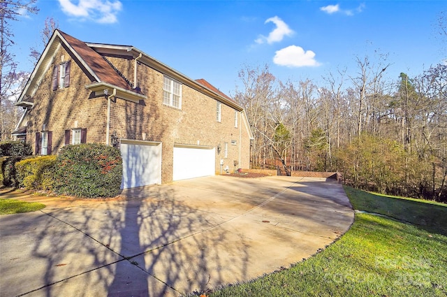 view of side of property with a garage, concrete driveway, and brick siding