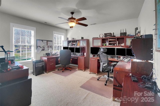 office area featuring a ceiling fan, visible vents, and plenty of natural light