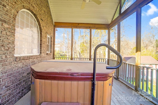 sunroom with plenty of natural light, a ceiling fan, and a hot tub