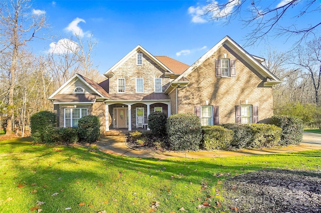 traditional home with brick siding, stone siding, and a front yard