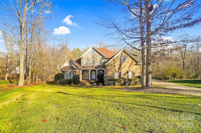 view of front of house with stone siding and a front lawn