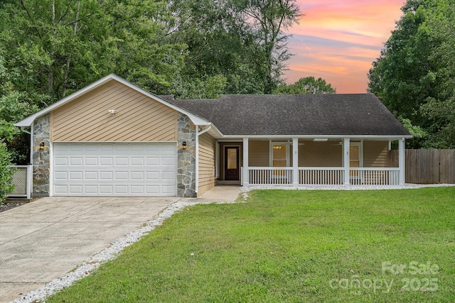 ranch-style house featuring a lawn, a porch, and a garage