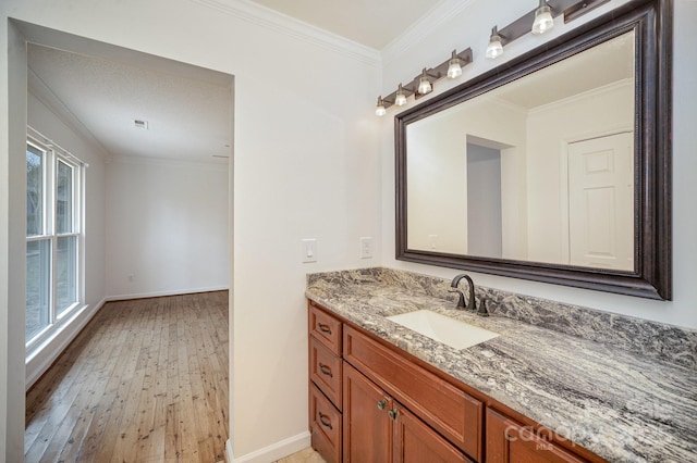 bathroom with plenty of natural light, vanity, hardwood / wood-style floors, and ornamental molding