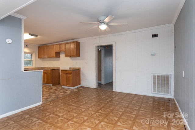 kitchen featuring ceiling fan, ornamental molding, and light parquet flooring