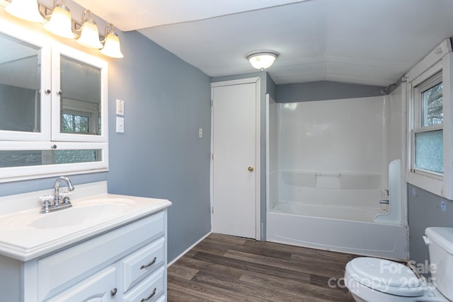 full bathroom featuring a healthy amount of sunlight, tub / shower combination, toilet, vanity, and hardwood / wood-style flooring