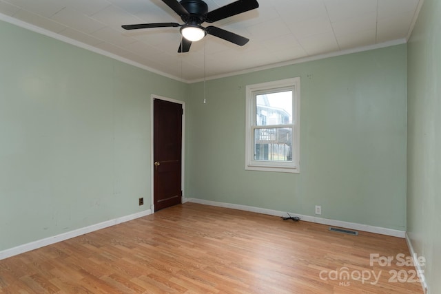 empty room with ceiling fan, light wood-type flooring, and ornamental molding