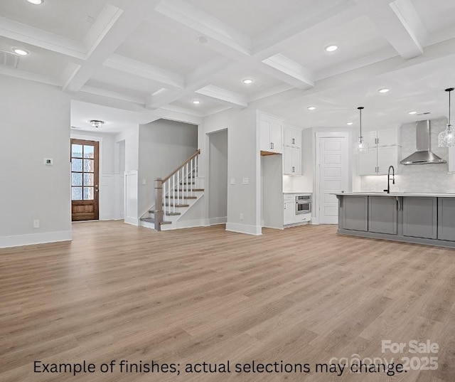 unfurnished living room featuring coffered ceiling, sink, beamed ceiling, and light hardwood / wood-style flooring