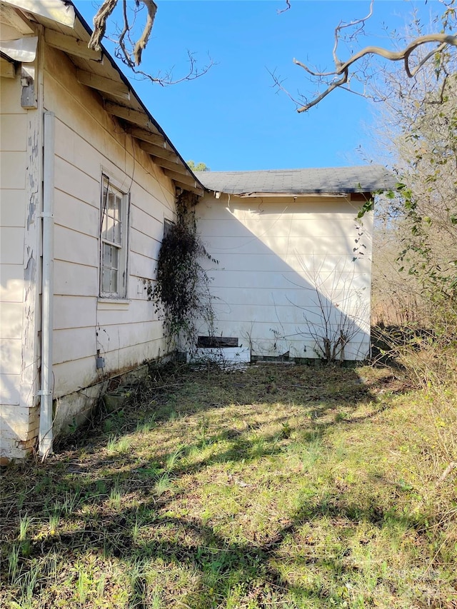 view of side of home with a yard