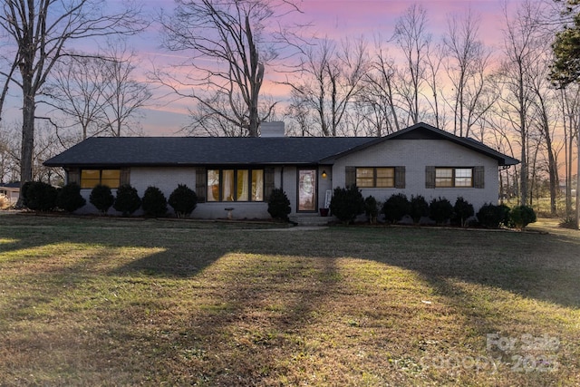 ranch-style home with a lawn