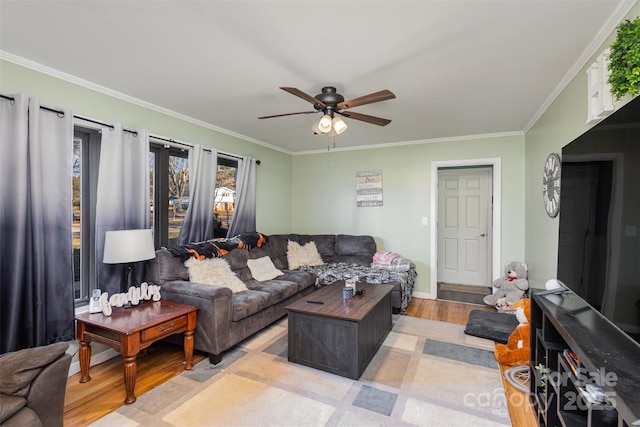 living room with light hardwood / wood-style flooring, ceiling fan, and crown molding