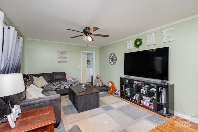 living room featuring light wood-type flooring, ceiling fan, and crown molding